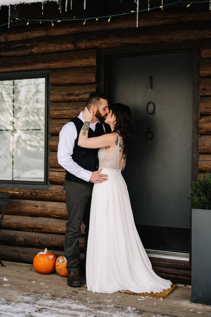 A bride and groom kiss outside a Scandia Inn room during their elopement.