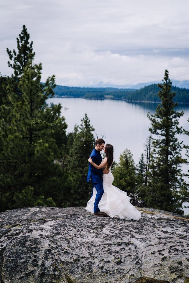 A couple dances on large rock overlooking Payette Lake during their Moonridge Cabin wedding in McCall, Idaho