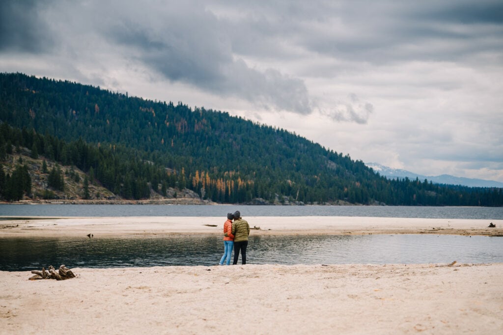 A couple stands looking out over Payette Lake in McCall, Idaho.
