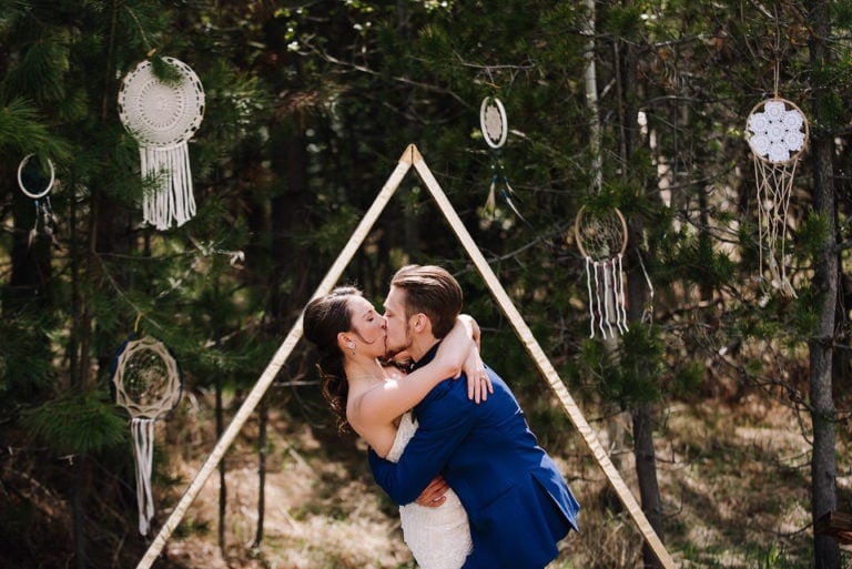 Couples exchanges their first kiss at their Moonridge Cabin wedding in McCall, Idaho