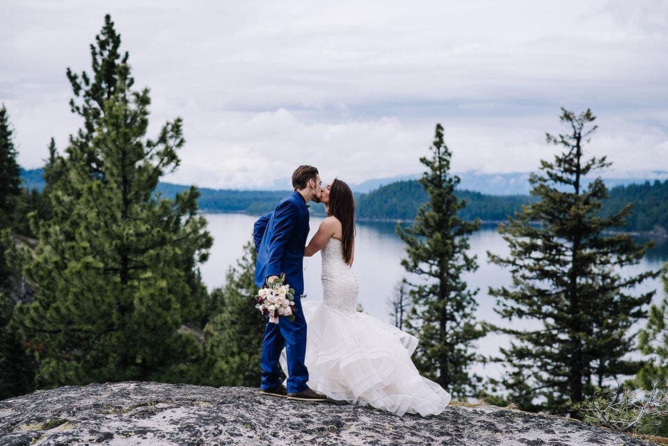 Groom kisses bride during their wedding day after session at Moonridge Cabin in McCall, Idaho.