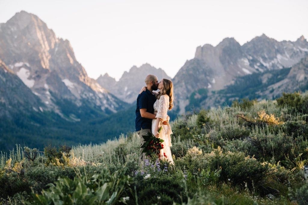Couple kisses with the Sawtooth Mountains behind them during their Stanley, Idaho elopement.
