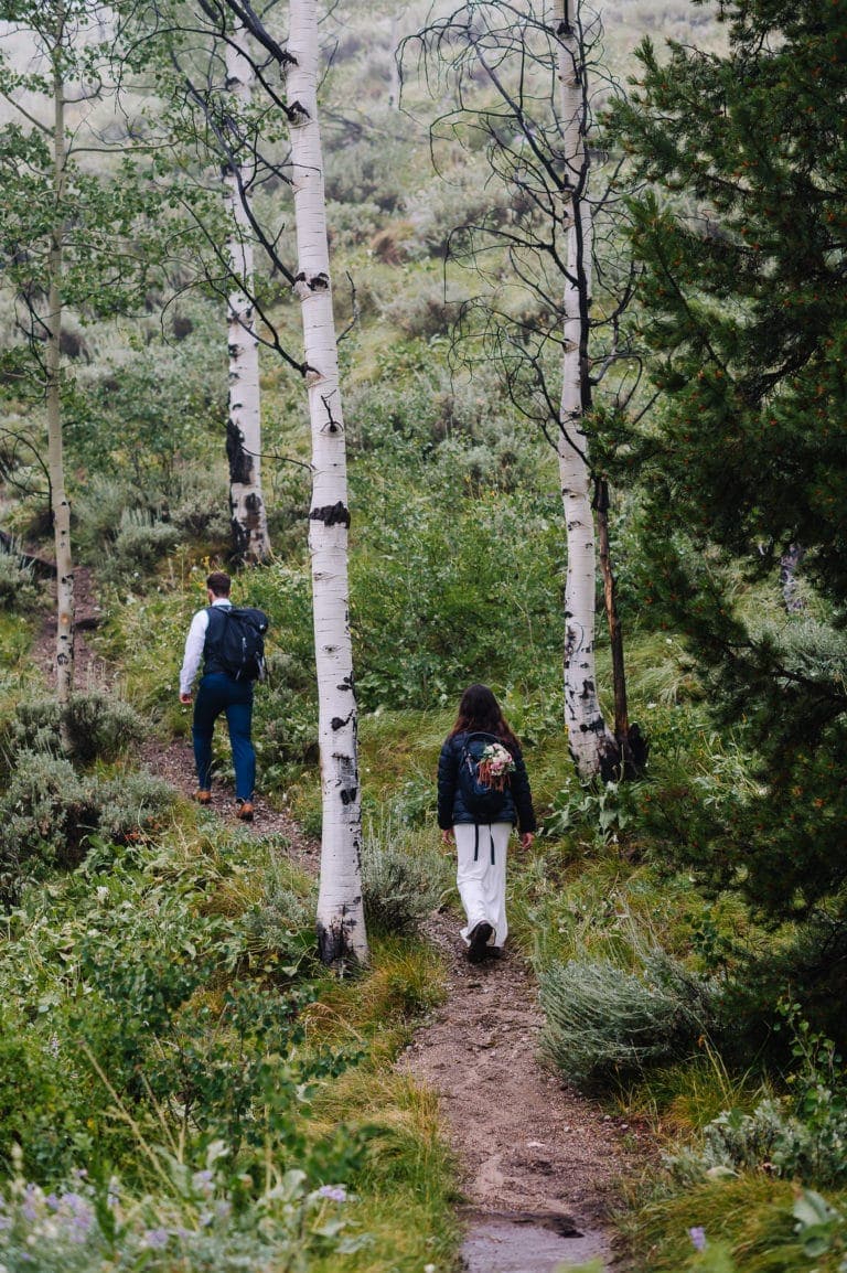 Elopement couple hikes through Aspen Trees during their Sawtooth Mountain Elopement.