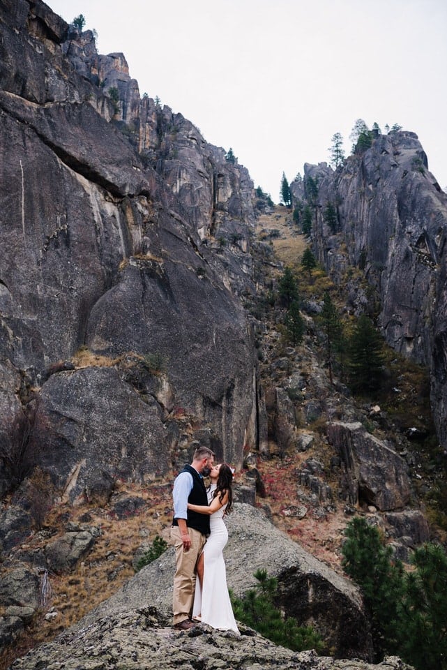 Couple stands among rock cliffs along the Salmon River during their Idaho elopement.