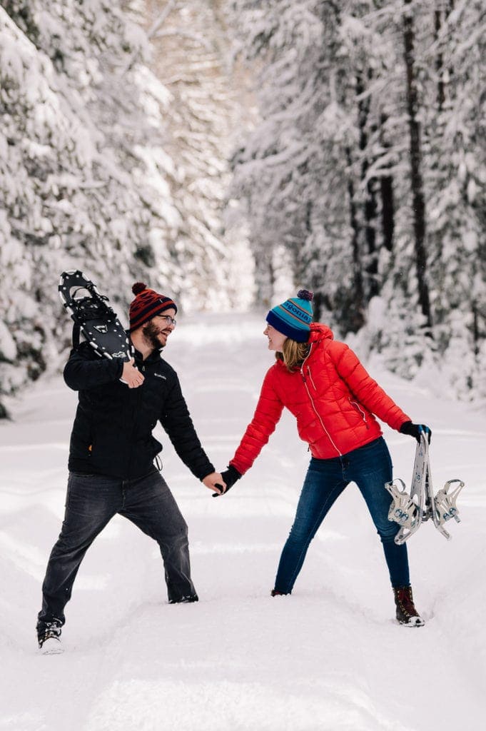 Couple stands on a snowy lane holding hands during their McCall engagement session.