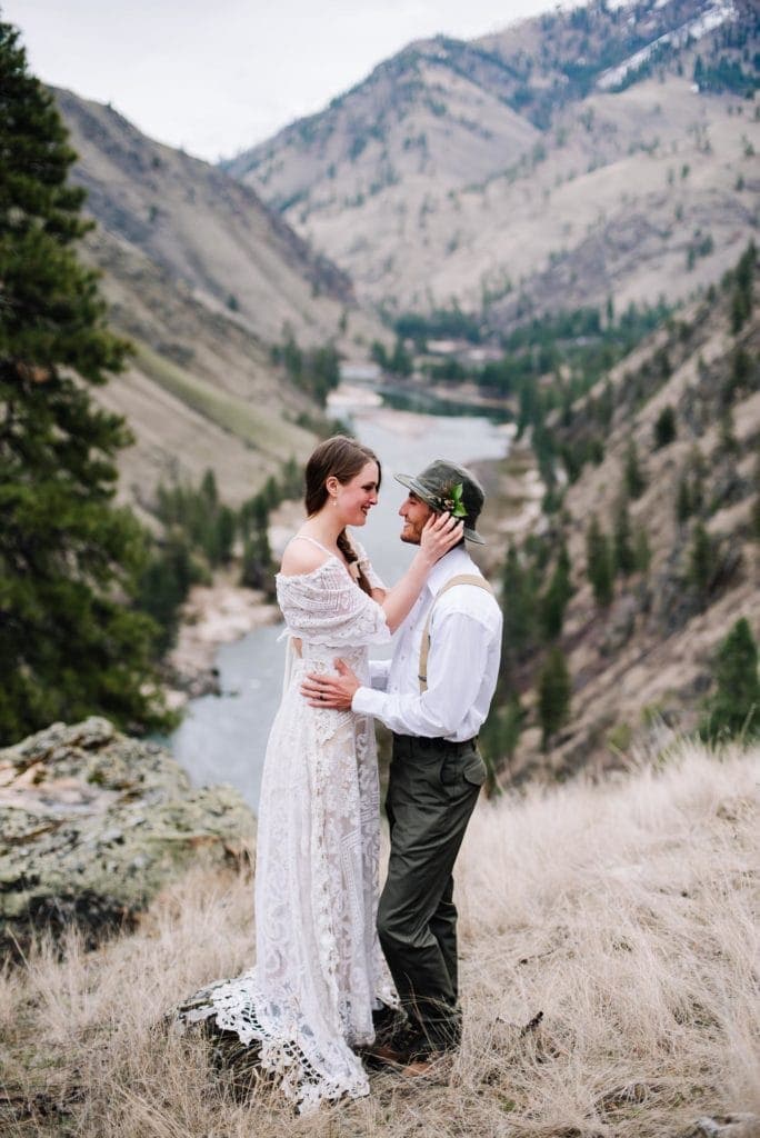 Bride and groom stand together with the salmon river behind them in Idaho. This image is part of an article on the best Airbnb wedding venues in Idaho.
