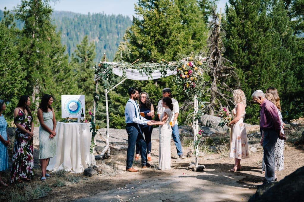 Bride and groom stand together under a chuppah during their Jewish wedding ceremony in McCall, Idaho.