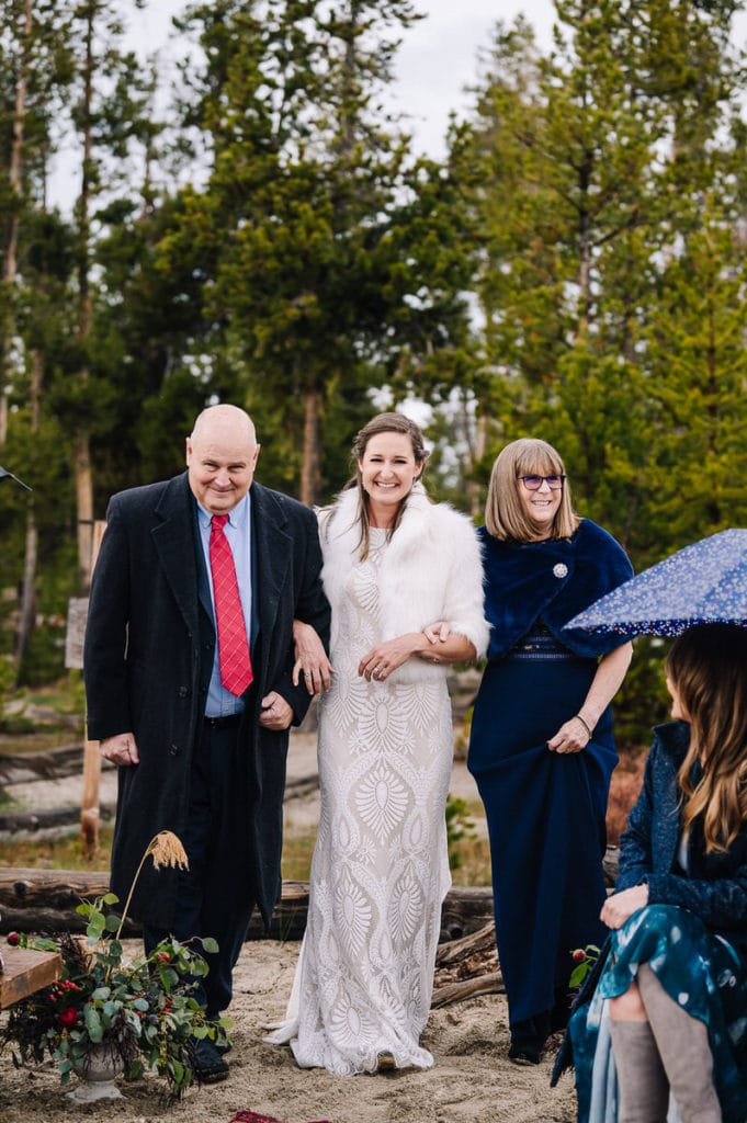 Bride walks down the aisle with both of her parents at her side.