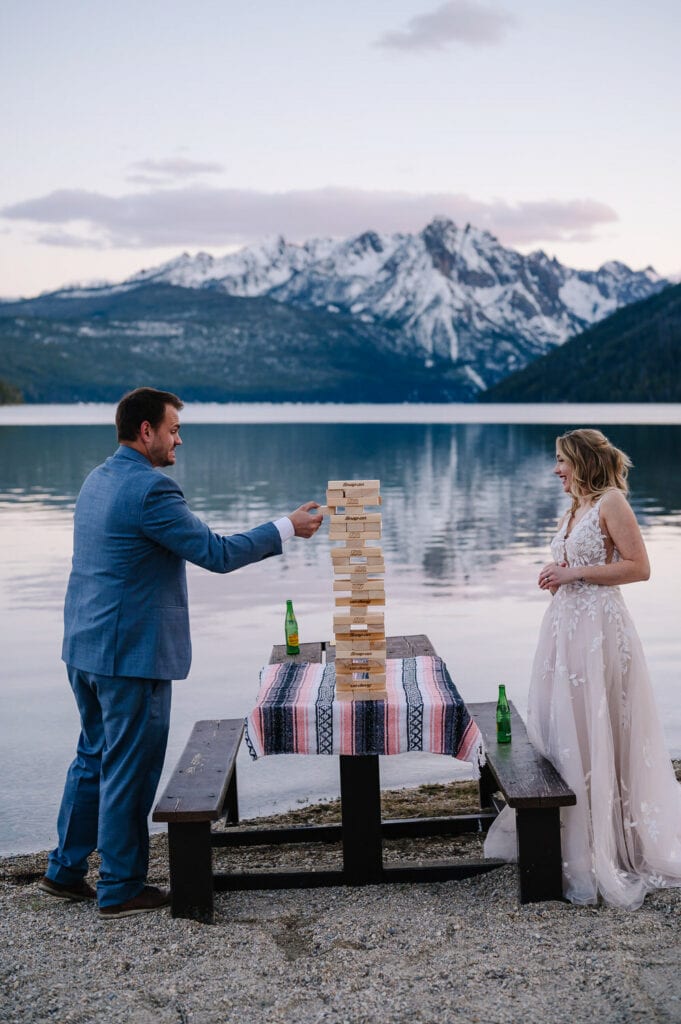 A couple plays a game of Jenga during their elopement. This is an example of a unique activity to include in a wedding day.